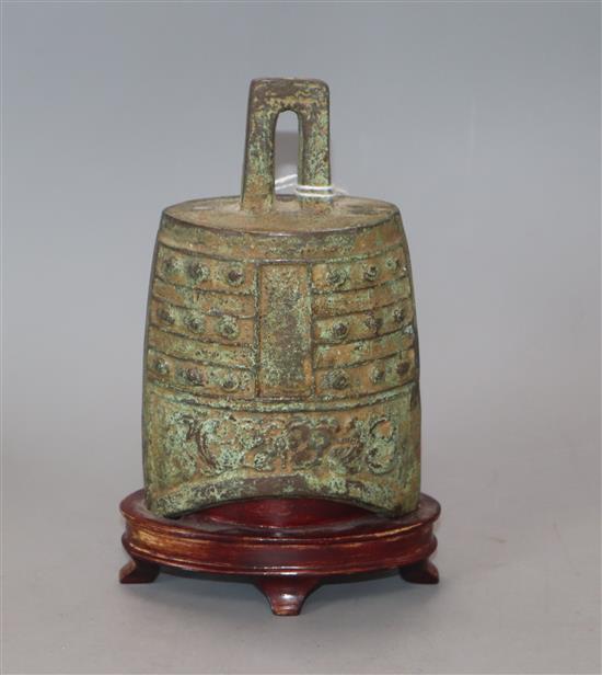 An archaistic bronze temple bell, on wooden stand overall height 15cm